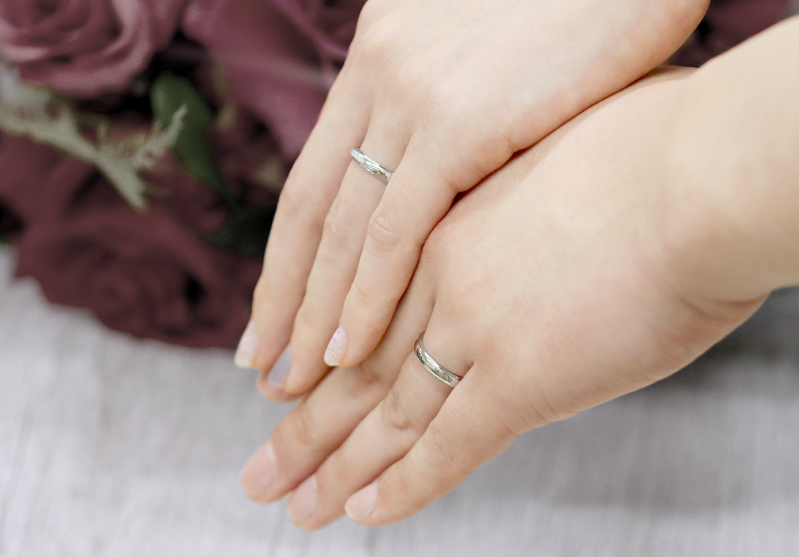2人の手が寄り添う、結婚指輪をはめている写真
